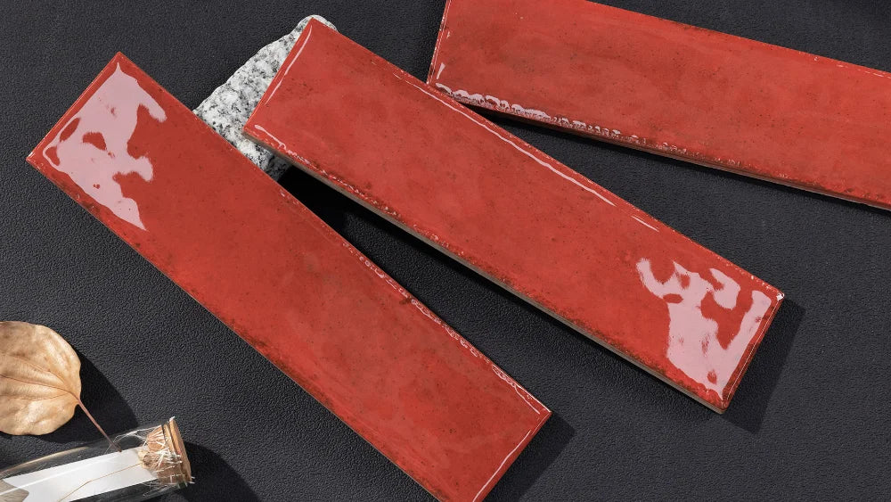 Three red tiles on a dark surface with a small decorative item.