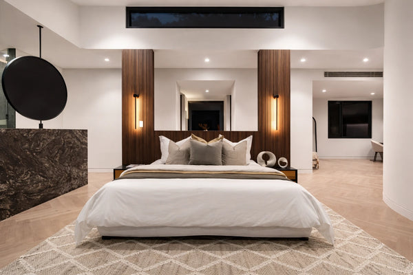 Modern bedroom with a large bed, wooden headboard, and decorative pillows.