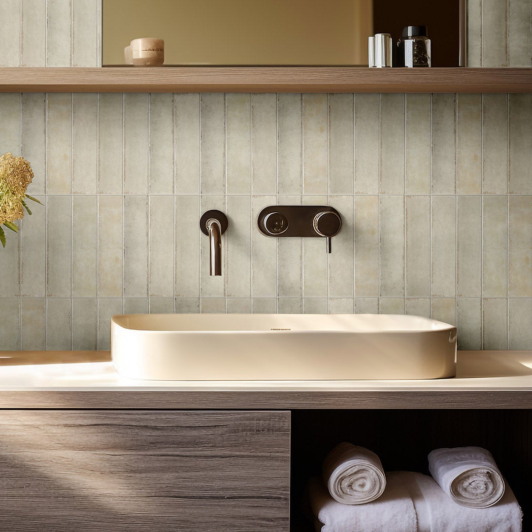 Modern bathroom with a sink, flowers, and candles on a shelf.