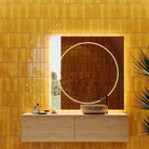 Bathroom with yellow tiled walls, a sink, and decorative plant.