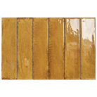Six rectangular glossy ceramic subway tiles in a warm mustard-gold and amber color with subtle brown speckling and natural glaze variation, arranged side-by-side on a white background.