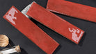 Three red tiles on a dark surface with a small decorative item.