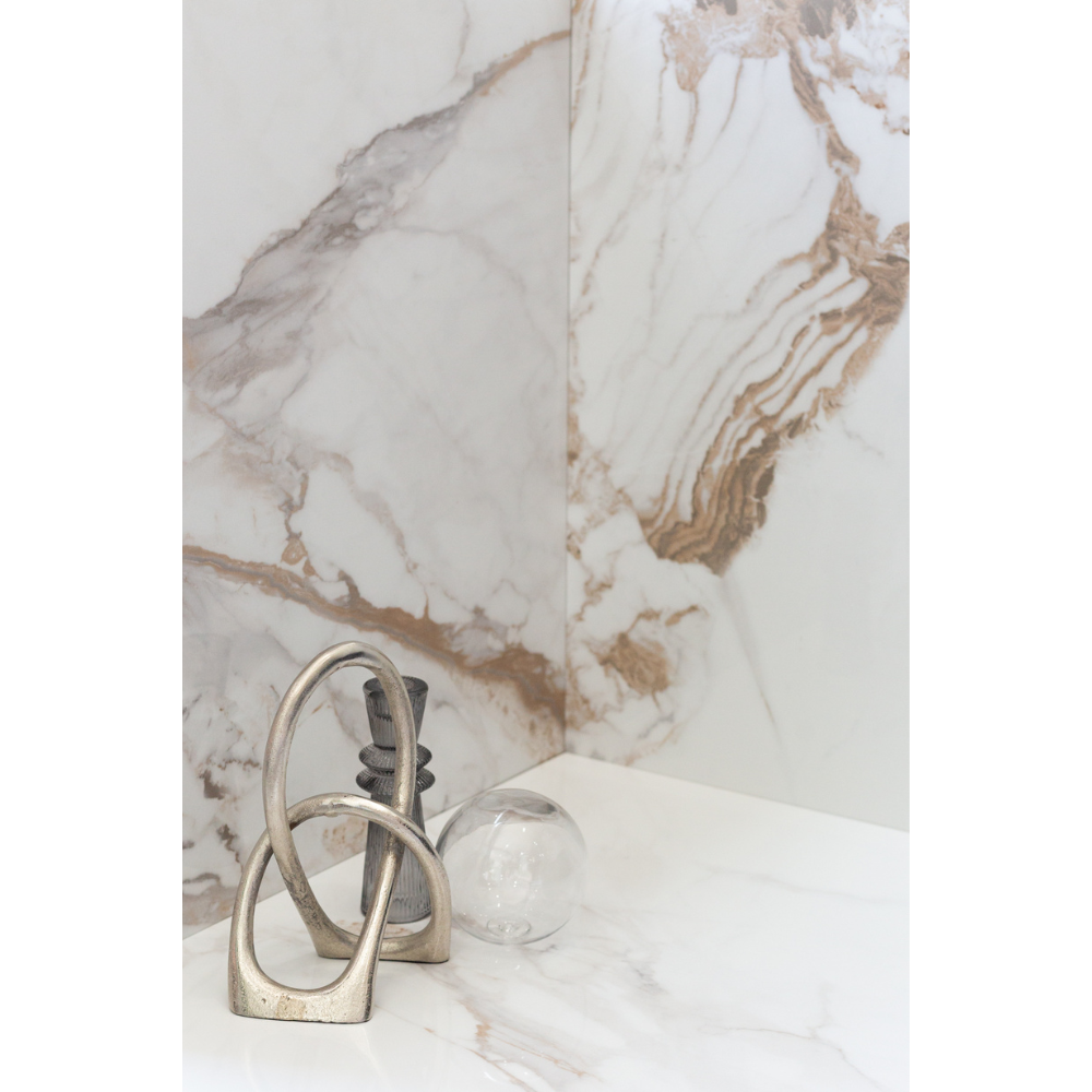 Showcase of Calacatta Oro marble-look tile in a corner.